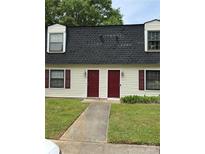 Charming townhome with red doors, matching shutters and dormer windows surrounded by a well-maintained lawn at 2224 Yorkhills Dr # 7, Charlotte, NC 28217