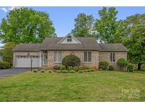 Charming brick home featuring an attached garage and a well-manicured front lawn, offering great curb appeal at 235 Pebble Point Rd, Salisbury, NC 28146