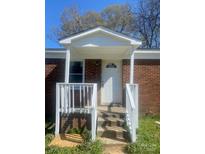 Charming brick home featuring a covered front porch and classic white front door at 2604 Booker Ave, Charlotte, NC 28216