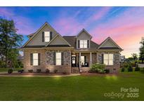 Charming brick and stone two-story home with manicured lawn and inviting front porch at 335 Wintergreen Ct, Kings Mountain, NC 28086