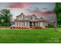 Charming single-Gathering home with manicured lawn, brick and stone facade, and inviting front porch at 335 Wintergreen Ct, Kings Mountain, NC 28086