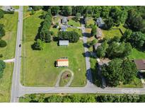 Aerial view of home with expansive green lawn and paved driveways, surrounded by mature trees and neighboring houses at 35 Telephone Exchange Rd, Hickory, NC 28601