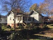 Charming home featuring white siding, inviting front porch, and a beautifully landscaped front yard at 4311 Commonwealth Ave, Charlotte, NC 28205