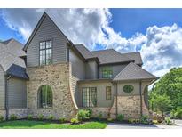 View of the house with a gray exterior, brick details, and multiple windows, set against a partly cloudy sky at 536 Hillside Ave, Charlotte, NC 28209