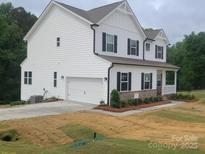 Charming two-story home with white siding, black shutters, attached garage, and a cozy front porch at 5630 Galloway Dr # 49, Stanfield, NC 28163