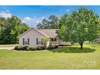 Charming single-story home with manicured lawn, mature tree, and covered front porch at 5678 Cedar Run Dr, Denver, NC 28037