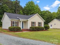 Charming single-story home with well-maintained lawn and detached garage at 6022 Windsong Way, Wingate, NC 28174