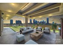 Relax on the covered patio with city skyline view, complete with seating and a faux grass area at 715 N Graham St # 603, Charlotte, NC 28202