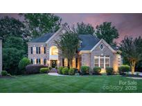 Elegant brick home boasts a manicured lawn, lush landscaping, and inviting curb appeal at 7501 Cleyera Cir, Waxhaw, NC 28173