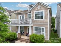 Charming two-story home with a covered porch and upper level balcony showcasing curb appeal at 10401 Royal Winchester Dr, Charlotte, NC 28277