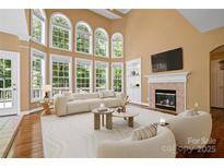 Bright living room boasts a fireplace, large windows, and soaring ceilings at 10616 Back Ridge Rd, Charlotte, NC 28277
