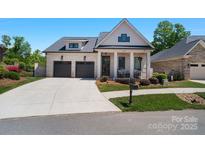Charming brick home featuring a two-car garage, inviting front porch and landscaped front yard at 1428 Spring Ridge Ln, Denver, NC 28037