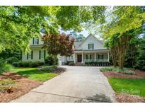 Charming two-story home with a covered front porch, lush landscaping, and an inviting driveway at 154 Patterson'S Bridge None, New London, NC 28127