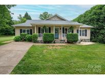 Charming ranch-style home with a welcoming front porch, lush landscaping and a well-manicured lawn at 1774 Smyrna Ln, Catawba, NC 28609