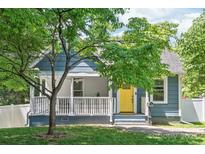 Charming blue home featuring a bright yellow front door, porch, and well-maintained lawn at 219 Lee St, Fort Mill, SC 29715