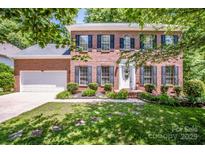 Beautiful two-story brick home featuring manicured landscaping, a white front door, and black shutters at 292 Rose St, Mooresville, NC 28117