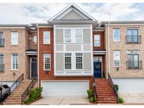 Charming townhome with brick facade, attached garage, and a welcoming blue front door at 3044 Luke Crossing Dr, Charlotte, NC 28226