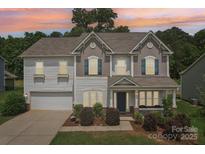 Charming two-story home with a well-manicured lawn and welcoming front porch at sunset at 3218 Gilroy Dr, Fort Mill, SC 29707