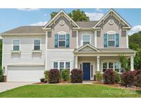 Well-maintained two-story home with a manicured lawn, blue shutters, and a welcoming front porch at 3218 Gilroy Dr, Fort Mill, SC 29707