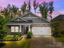 Charming home featuring stone accents, a two-car garage, and well-maintained landscaping at 4008 Leyland Ct, Charlotte, NC 28227