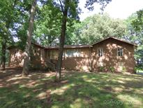 Traditional brick home with mature trees and landscaping around the front yard at 4476 Nc Hwy 200 Rd, Stanfield, NC 28163