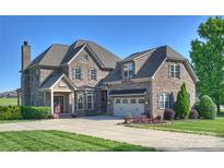 Beautiful brick home featuring a well manicured lawn, mature landscaping and a three car garage at 4941 Campobello Dr, Monroe, NC 28110