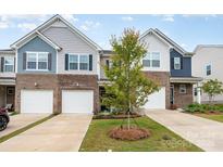 Charming townhome featuring mixed siding, brick accents, and a one car garage at 6011 Chelsea Oaks Rdg, Tega Cay, SC 29708
