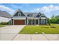 Charming single-Gathering home featuring a well-manicured lawn, a two-car garage, and welcoming front porch at 605 Brennan St # 31, Mount Pleasant, NC 28124