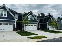 Charming blue townhomes boast white garage doors, stone accents, and well-manicured landscaping at 934 Prince Garrett Way, Denver, NC 28037