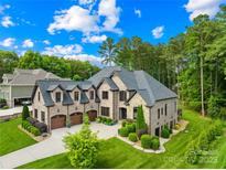 Stately brick and stone home with mature trees, a three-car garage, and manicured landscaping at 107 Blue Ridge Trl, Mooresville, NC 28117