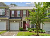 Charming brick townhouse features a one-car garage, manicured lawn, and a classic front door at 108 N Arcadian Way, Mooresville, NC 28117