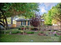 Charming brick home featuring a cozy front yard with mature trees and quaint rustic accents at 1111 Green Street Ext, Rock Hill, SC 29730