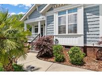 Charming home entrance with landscaped walkway, featuring gray siding and classic architectural details at 1201 Pegram St, Charlotte, NC 28205