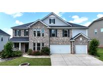Charming two-story home with a brick facade, two-car garage, and well-manicured lawn at 1281 Arges River Dr, Fort Mill, SC 29715