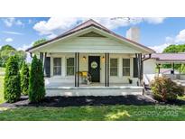 Charming front porch with a 'Welcome' sign and lovely decorative plants and shrubs at 1300 Nc 90 W Hwy, Taylorsville, NC 28681