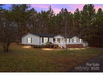 Charming single-story home featuring white siding, a brick foundation, and a welcoming front porch with stair access at 1370 Poole Rd, Salisbury, NC 28146