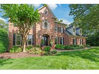 Beautiful brick home featuring manicured landscaping, a stately front entrance, and black shutters at 14701 Jockeys Ridge Dr, Charlotte, NC 28277