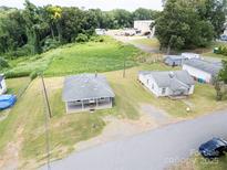 Aerial view featuring two single-story homes, a large grassy lot, and mature trees at 206 13Th St, Belmont, NC 28012