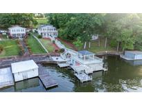 Stunning aerial view of the lakefront homes, steps to the water, and boat dock at 24264 Strand Dr, Albemarle, NC 28001