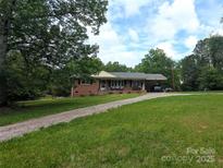 Charming brick home featuring an expansive front yard with mature trees and a covered carport at 3116 Pilgrim Rd, Chester, SC 29706