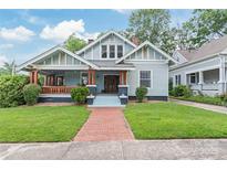 Charming home featuring a welcoming front porch, brick walkway, and well-manicured lawn, perfect for outdoor living at 319 S Oakland St, Gastonia, NC 28052
