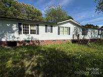 Charming single-story home with black shutters and a brick foundation, set in a tranquil, wooded neighborhood at 33 Honeysuckle Ln, Taylorsville, NC 28681