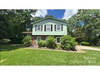 Charming two-story home with a well-manicured lawn and lush landscaping at 5772 Gettysburg Nw Dr, Concord, NC 28027