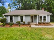 Charming single-story home with light blue siding, white trim, and well-manicured landscaping at 6041 Misty Way Ln, Charlotte, NC 28212