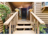 Inviting entryway with warm wood steps, flower pots, and a welcoming blue 'Home' doormat at 9013 St Croix Ln, Charlotte, NC 28277
