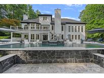 Luxury home featuring an inviting in-ground pool, complete with a beautiful stone waterfall and lounging area at 1001 Berwick Ct, Waxhaw, NC 28173