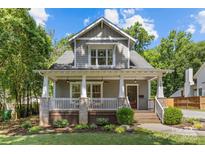 Charming two-story home featuring a welcoming front porch, beautifully landscaped yard, and classic architectural details at 1241 Rollins Ave, Charlotte, NC 28205