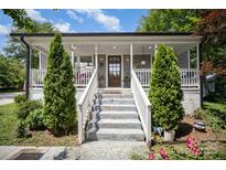 Charming front porch with a white railing, front door, and plants create a welcoming entrance at 131 Swink Sw St, Concord, NC 28027