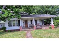 Charming home featuring a cozy front porch with brick support pillars, perfect for enjoying the outdoors at 1313 Maiden E Rd, Maiden, NC 28650