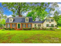 Charming two-story home with a brick facade, dormer windows, green door and shutters, and mature landscaping at 1581 Granville Rd, Rock Hill, SC 29732